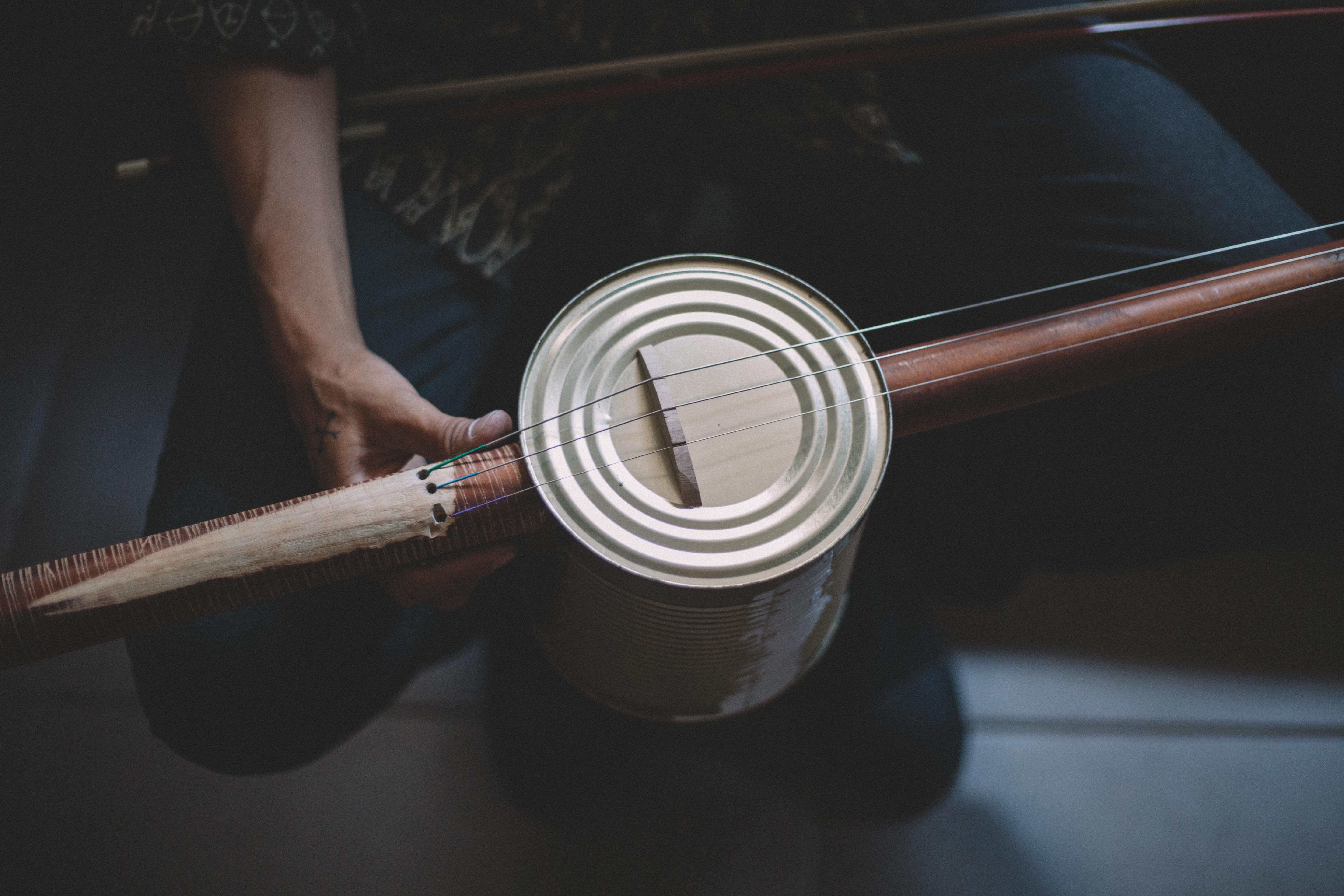 Hands playing a tin-can fiddle
